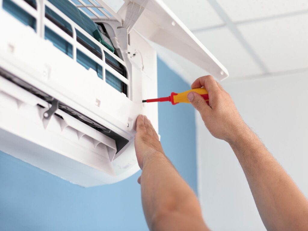 Hands performing Air Conditioning Repair, to ensure HVAC systems are functioning properly..