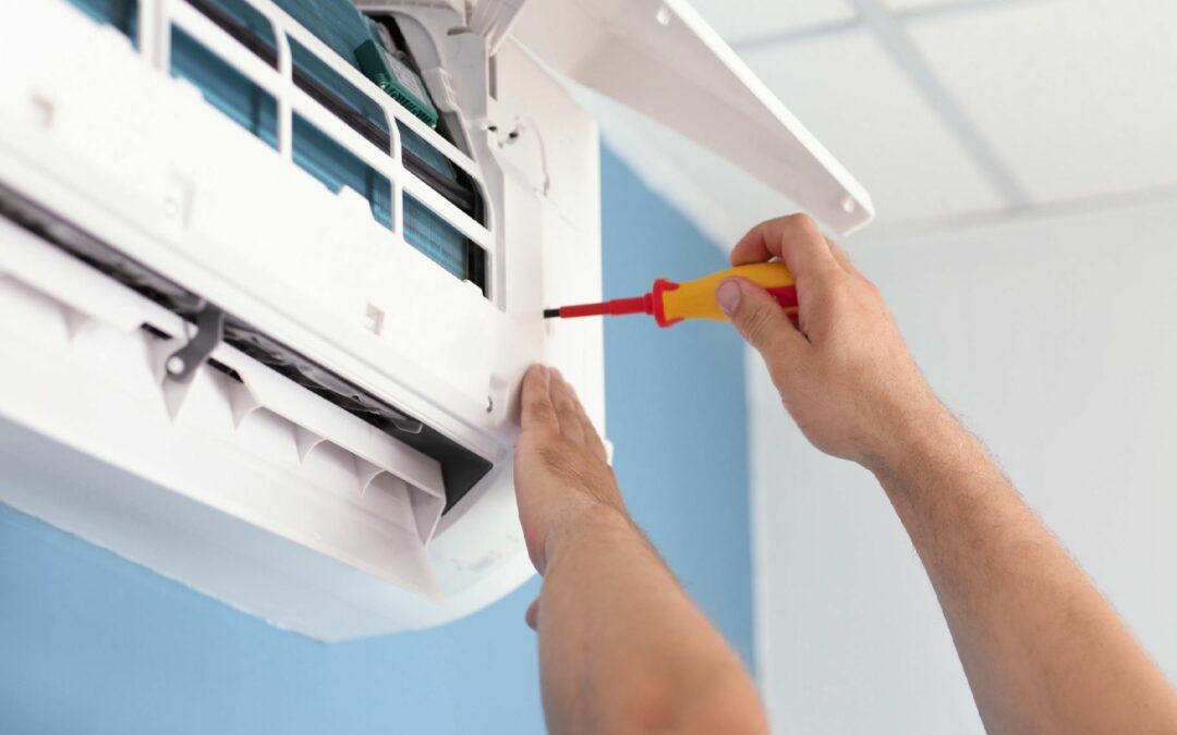 Hands performing Air Conditioning Repair, to ensure HVAC systems are functioning properly..