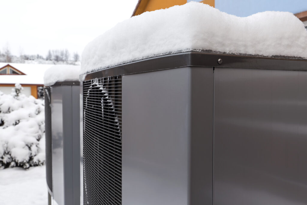 Two residential modern heat pumps buried in snow