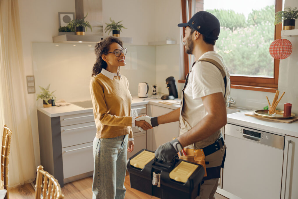 Homeowner welcoming a professional technician at home as part of a home services membership